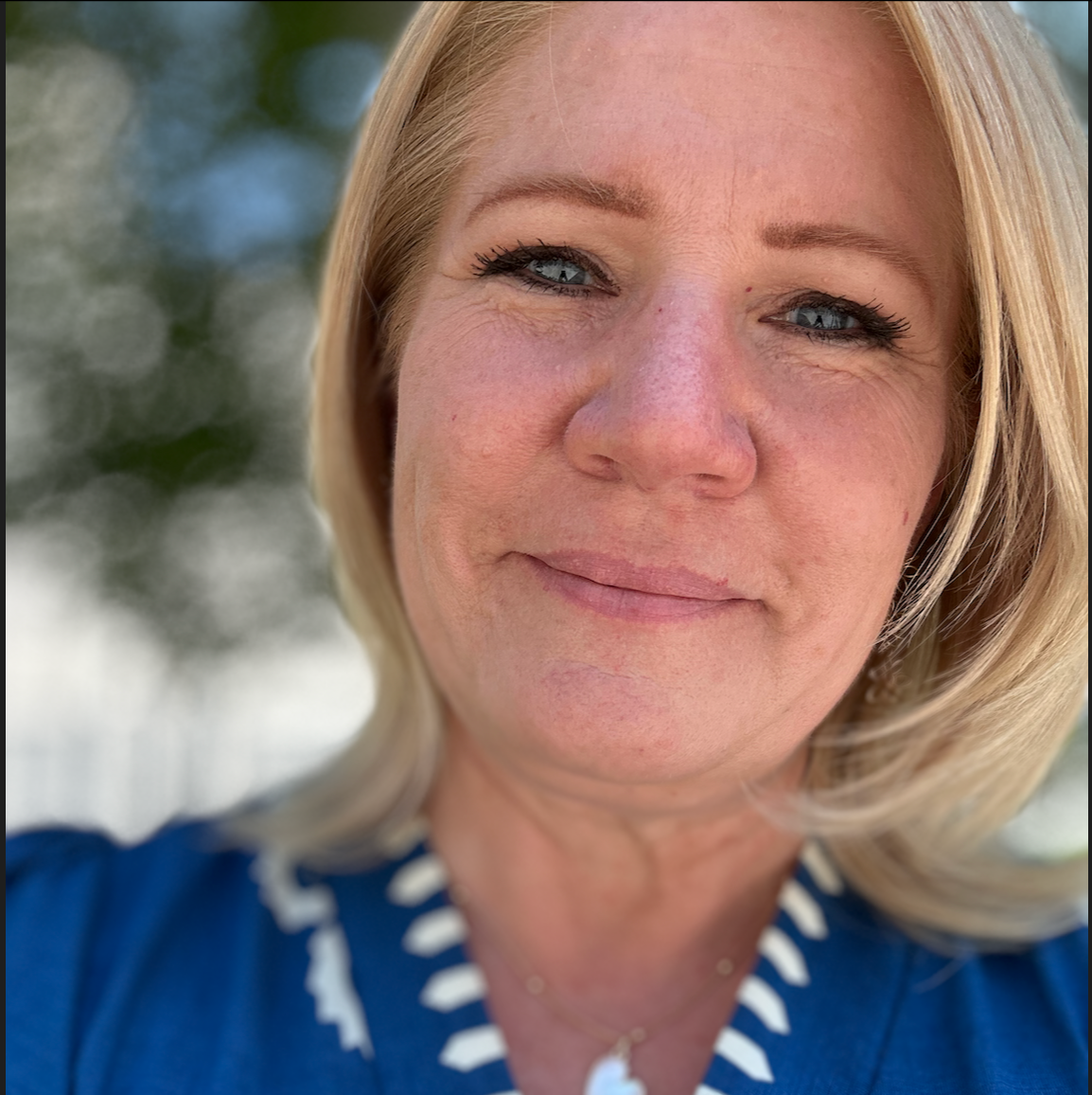Photo of Jessica Lemon with blonde hair wearing a blue top with white trim outdoors